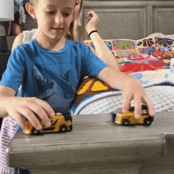 Two gold cars roll together and transform into a dinosaur during shared play