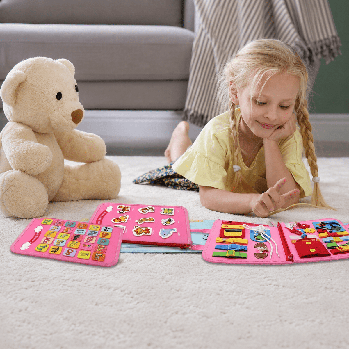 Child playing with the pink busy board activity book at home
